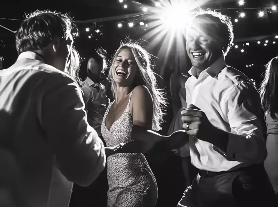 A newlywed couple share their first dance under sparkling lights at their wedding reception.